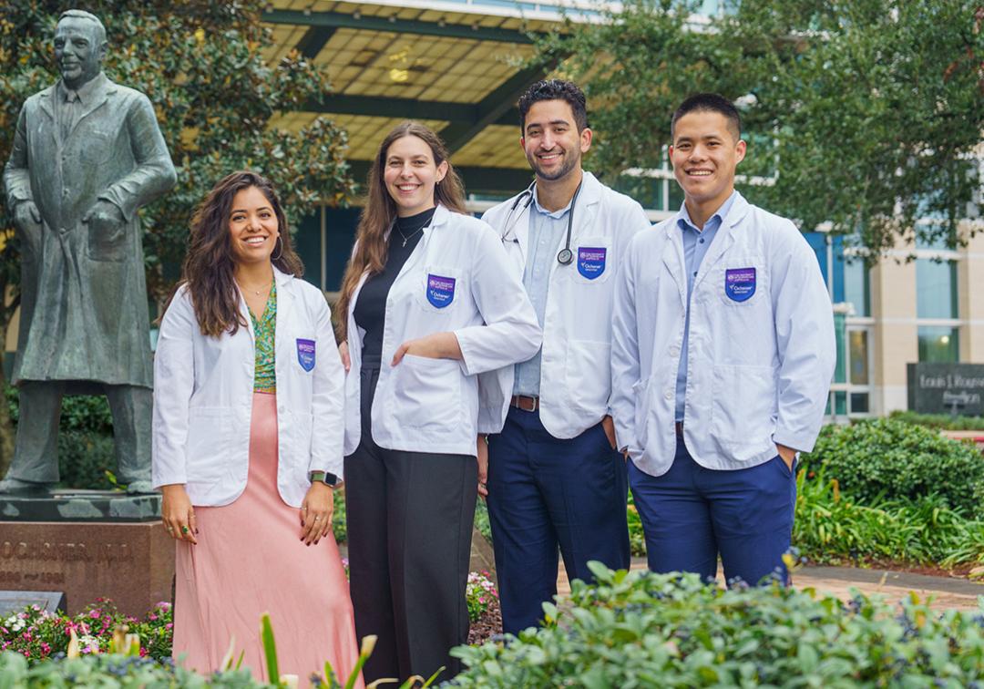 Four students standing in front of a building