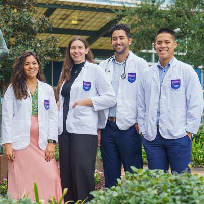 Four students standing in front of an Ochsner Health building