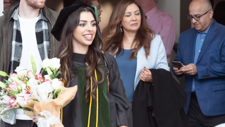 Graduating UQ-Ochsner MD student holding a bunch of flowers.