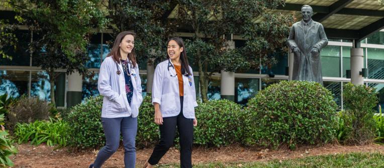 Students walking past statue