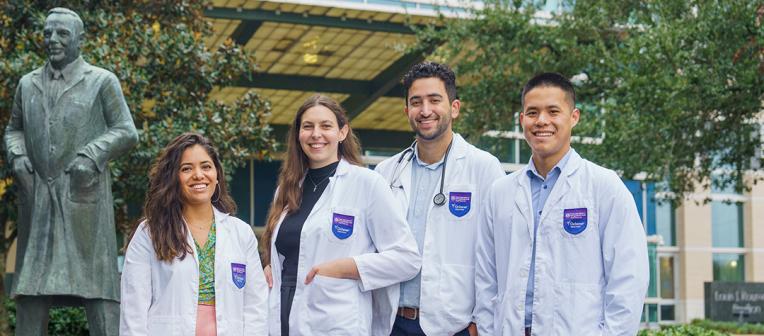 Four students standing in front of a building