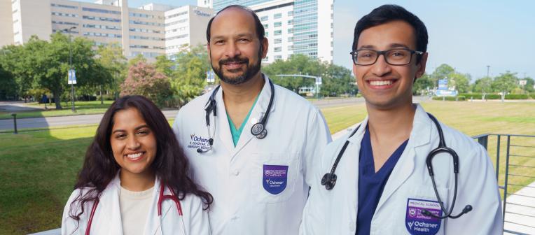 2 UQ-Ochsner Students and a doctor standing in front of the Ochsner Health Campus in New Orleans