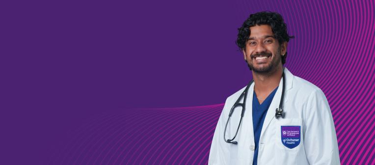 Smiling medical student in front of a purple background