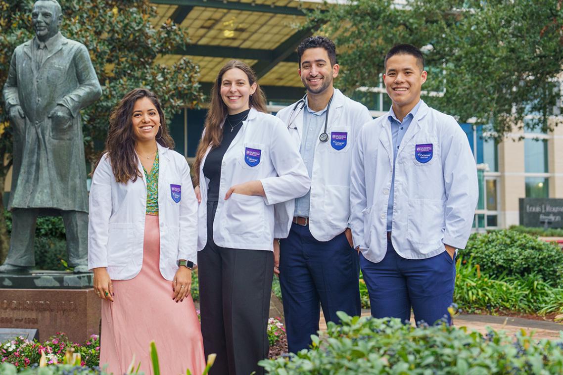 Four students standing in front of a building