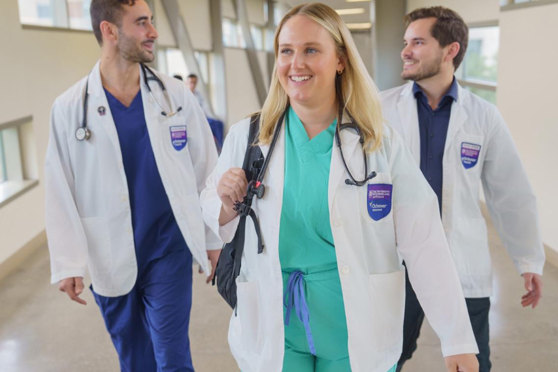 Three students walking down hospital hallway